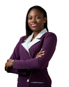Picture of Jane OLUWADARE turned slightly to the side, with a bright smile and her arms crossed. She is wearing a purple blazer dress with white lapels and small gold butterfly earring studs. Her hair is down in a side part