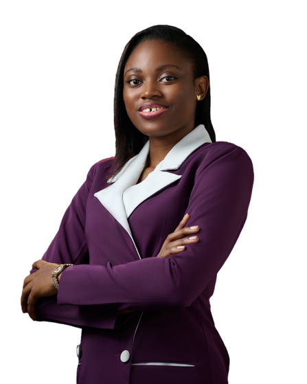 Picture of Jane OLUWADARE turned slightly to the side, with a bright smile and her arms crossed. She is wearing a purple blazer dress with white lapels and small gold butterfly earring studs. Her hair is down in a side part